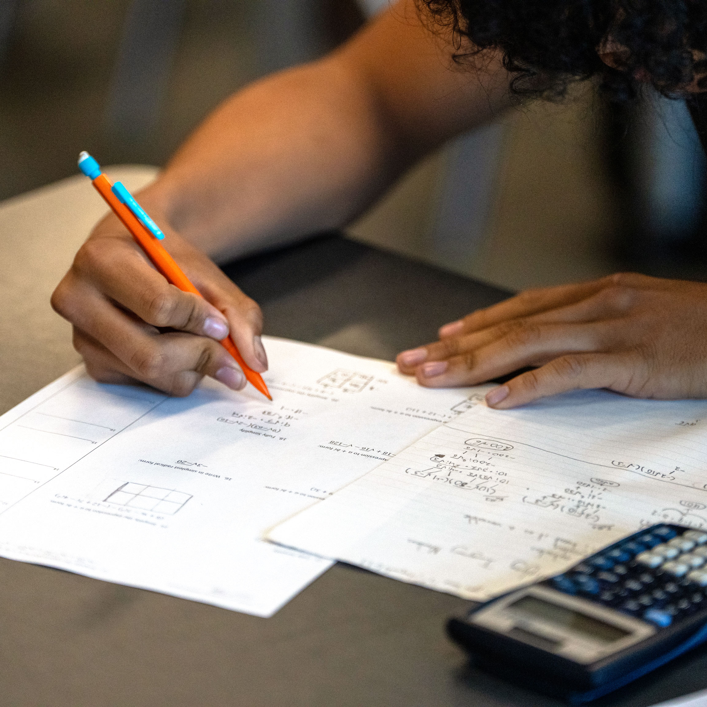 Student with math worksheets and calculator
